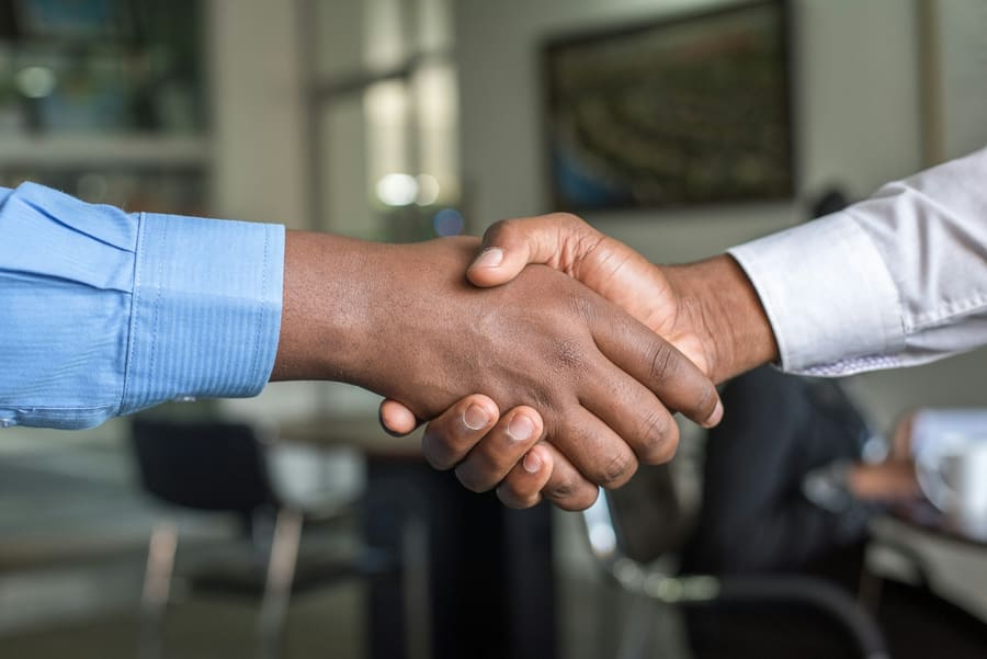 Jabat tangan dua profesional berjas menandai kesepakatan kerja sama